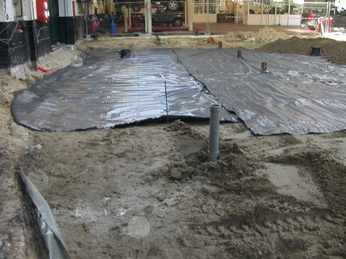 Plaatsen van een folie voor onder de nieuwe betonverharding.